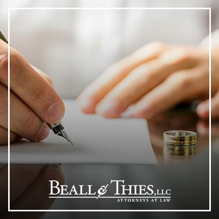 Hands signing a paper document
